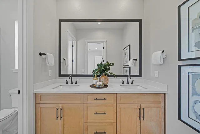 a bathroom with a granite countertop double vanity sink and a mirror