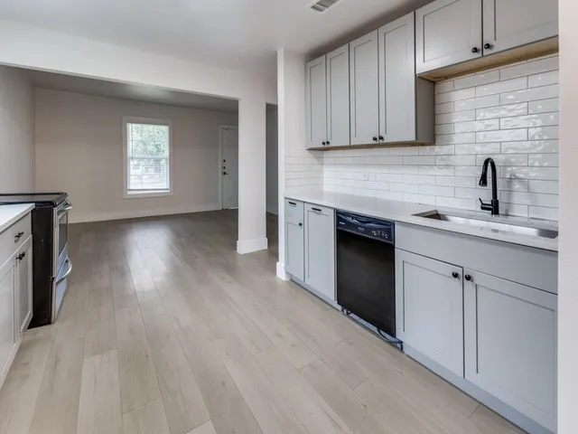 a kitchen with granite countertop a sink cabinets stainless steel appliances and a counter space