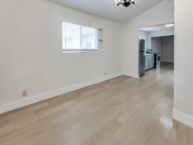 an empty room with a window and wooden floor