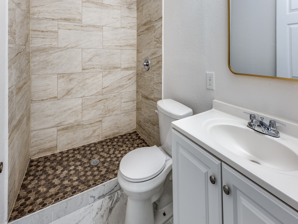 1108 Vasquez Street Austin, TX 78741 - Photo 24 of 33 a bathroom with a sink a toilet and a mirror