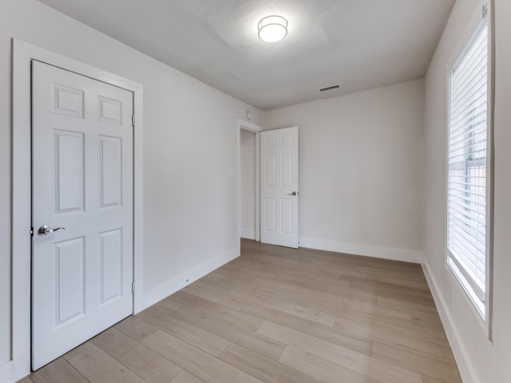 1108 Vasquez Street Austin, TX 78741 - Photo 25 of 33 an empty room with wooden floor and windows