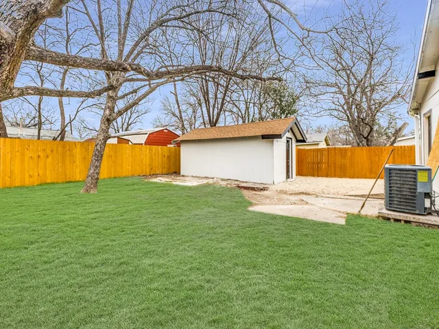 a view of a house with backyard and sitting area