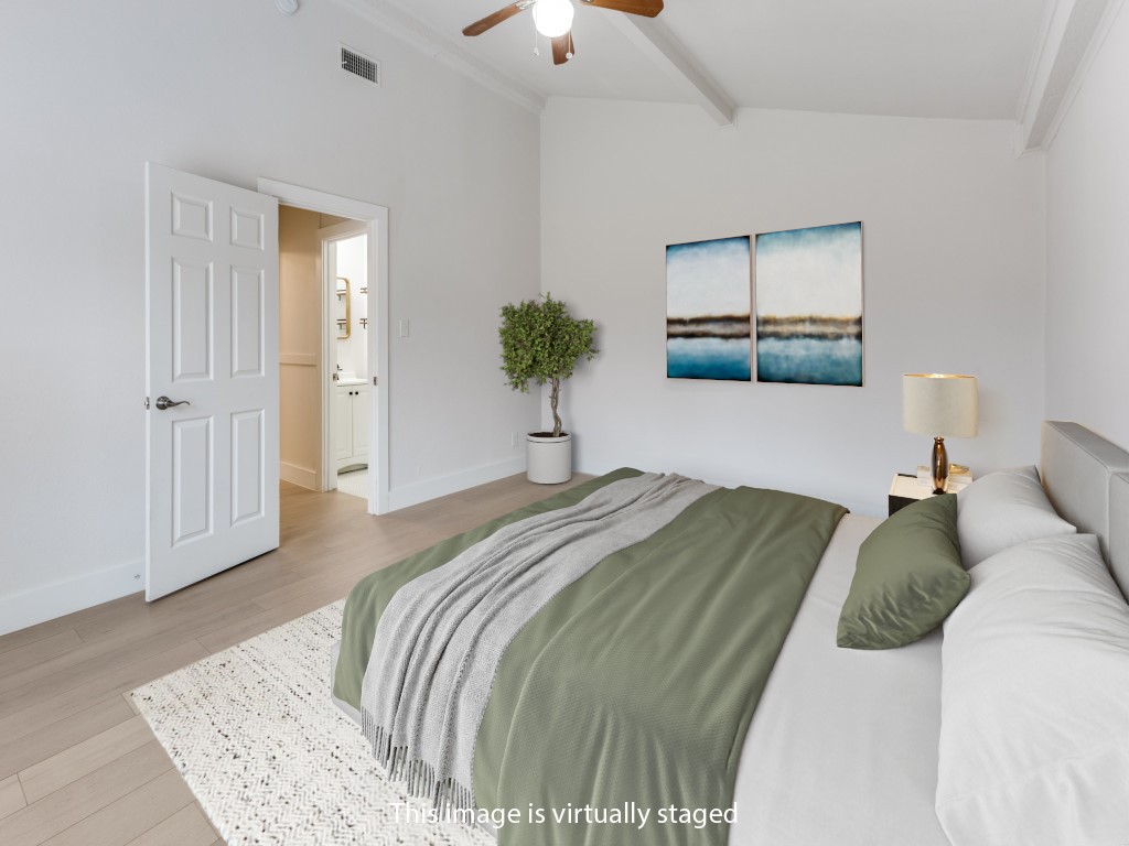 1108 Vasquez Street Austin, TX 78741 - Photo 5 of 33 a bedroom with a bed and a chandelier