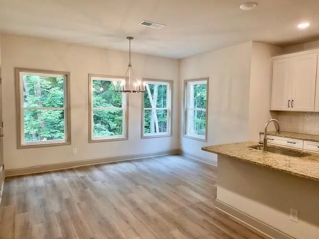 a kitchen with granite countertop a stove a sink and wooden floor