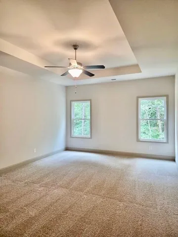 en empty room with windows and chandelier fan