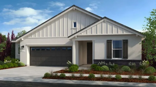 a front view of a house with a yard and potted plants