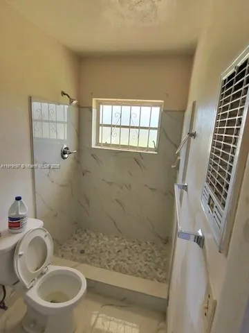 a bathroom with a granite countertop toilet sink and shower