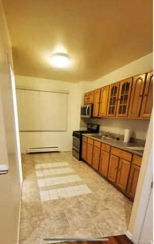 a view of a kitchen with an empty space and wooden floor