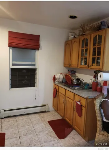 a utility room with stainless steel appliances granite countertop a stove a sink and a microwave