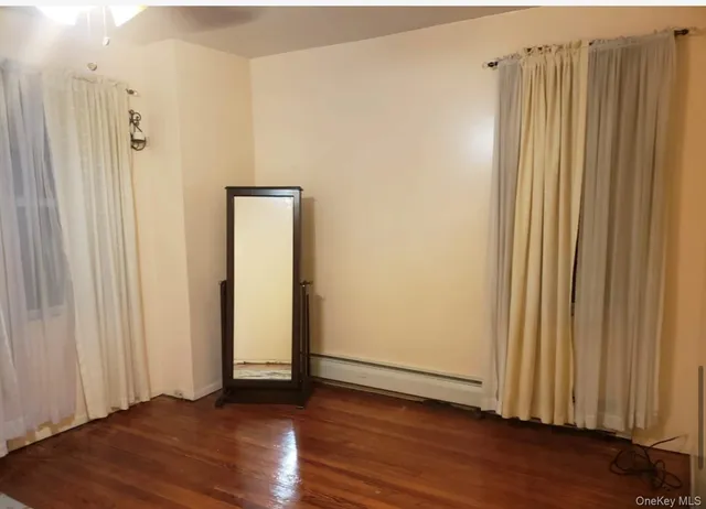 an empty room with wooden floor and closet area