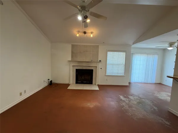an empty room with windows and fireplace