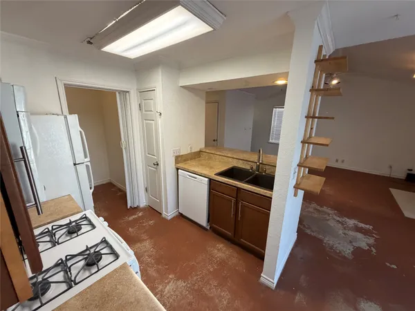 a kitchen with sink refrigerator and cabinets