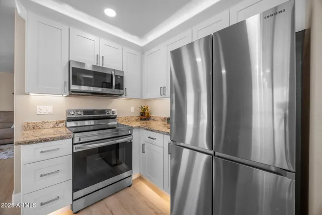 a kitchen with stainless steel appliances granite countertop a refrigerator and a sink