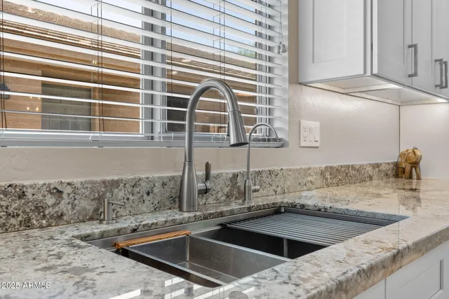 a kitchen with kitchen island granite countertop wooden floors and refrigerator