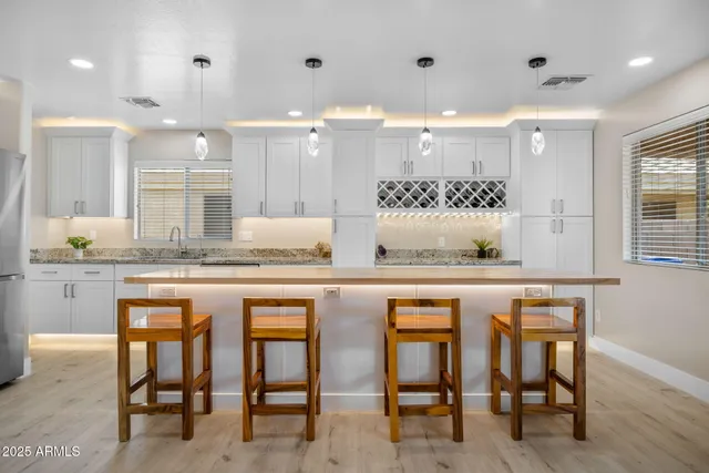 a kitchen with stainless steel appliances granite countertop a refrigerator sink and stove