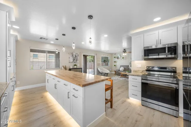 a kitchen with stainless steel appliances a refrigerator sink and microwave