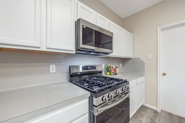 a view of empty room with wooden floor and ceiling fan