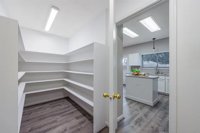 an empty room with wooden floor a ceiling fan and windows