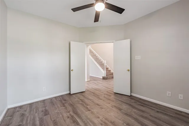 a view of a room with wooden floor fan and a window