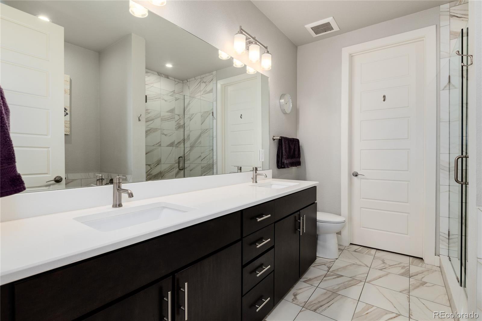 2436 North Washington Street Denver, CO 80205 - Photo 18 of 30 a bathroom with a sink double vanity and a mirror