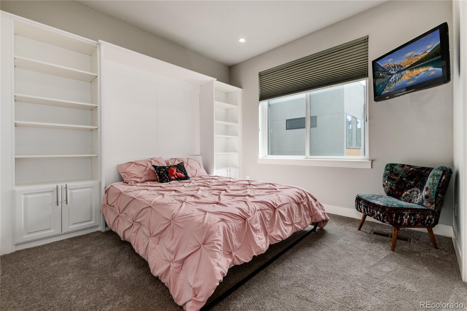 2436 North Washington Street Denver, CO 80205 - Photo 21 of 30 a bedroom with a bed and chair