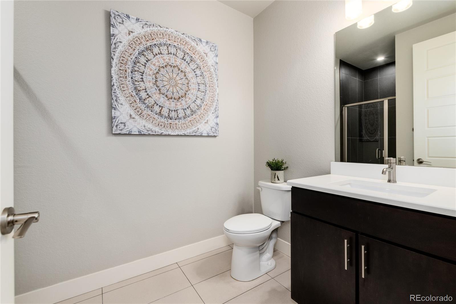 2436 North Washington Street Denver, CO 80205 - Photo 22 of 30 a bathroom with a toilet sink and mirror