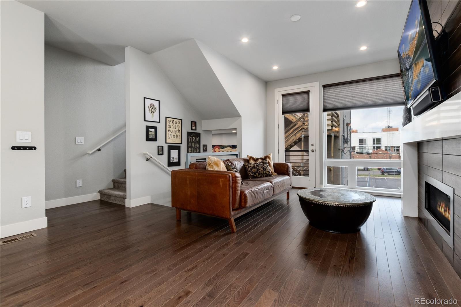 2436 North Washington Street Denver, CO 80205 - Photo 8 of 30 a living room with fireplace furniture and a wooden floor