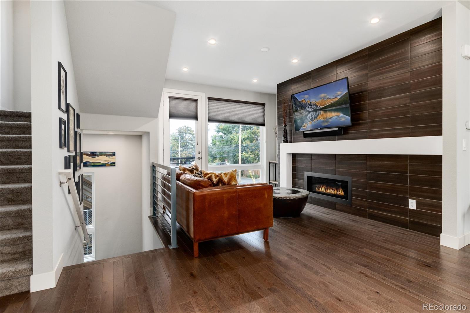 2436 North Washington Street Denver, CO 80205 - Photo 9 of 30 a living room with furniture a flat screen tv and a fireplace