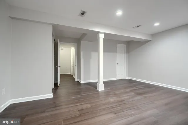 a view of an empty room with wooden floor
