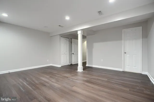 a view of an empty room with wooden floor