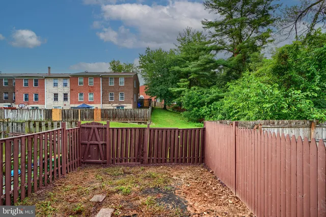a view of a brick house with wooden fence