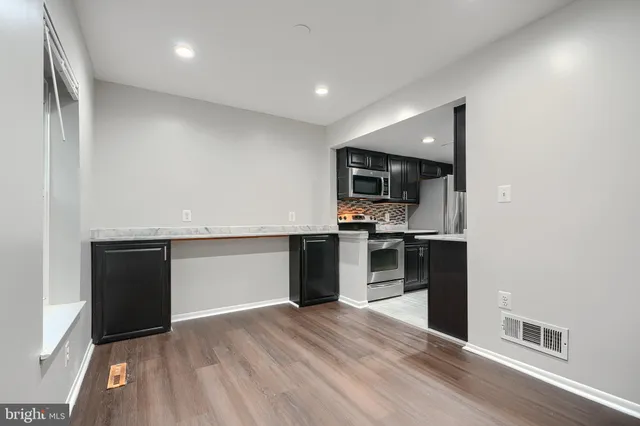 a view of kitchen with refrigerator and microwave