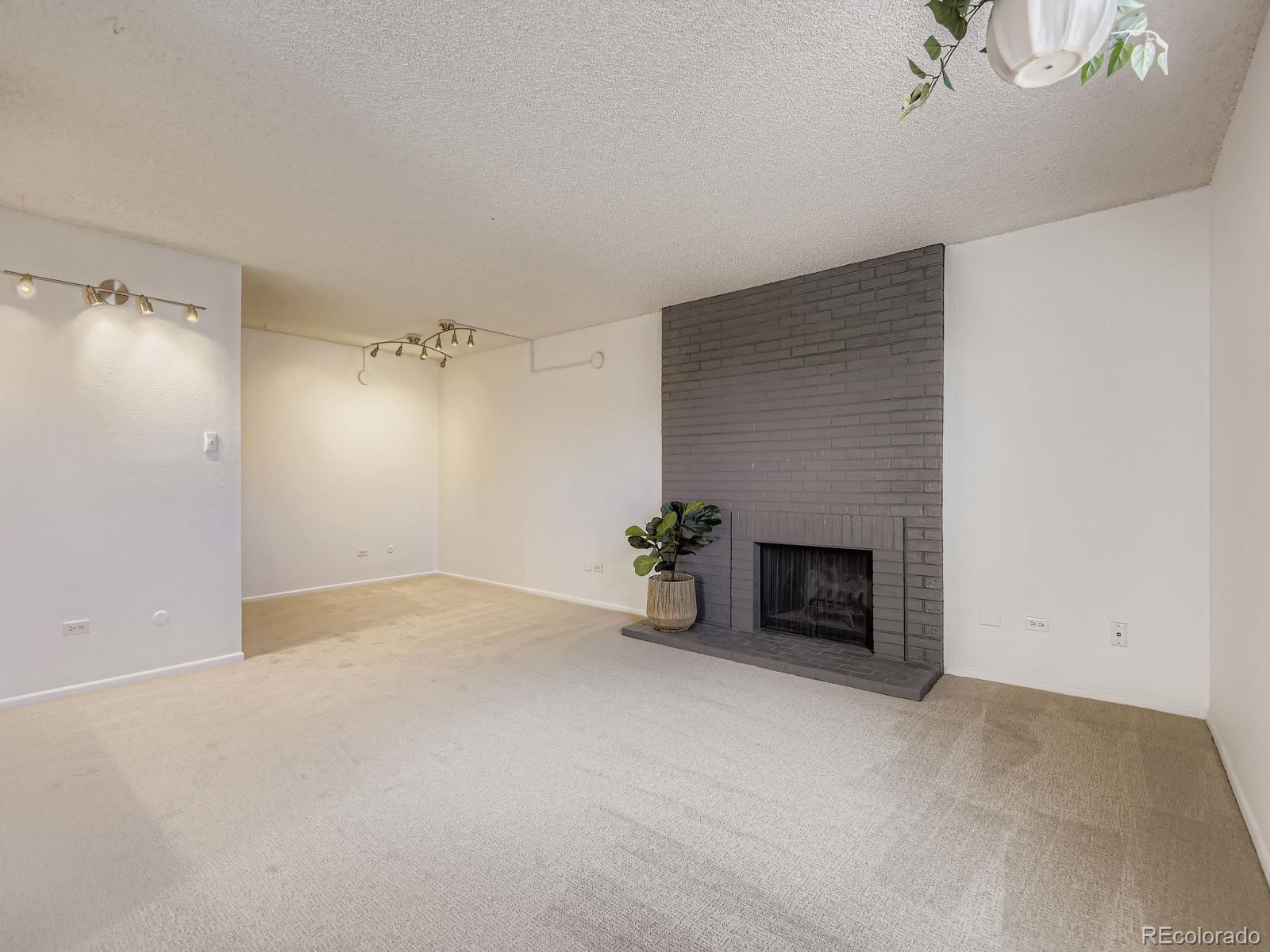 3323 South Monaco Street, Unit D Denver, CO 80222 - Photo 5 of 27 a view of empty room with a fireplace