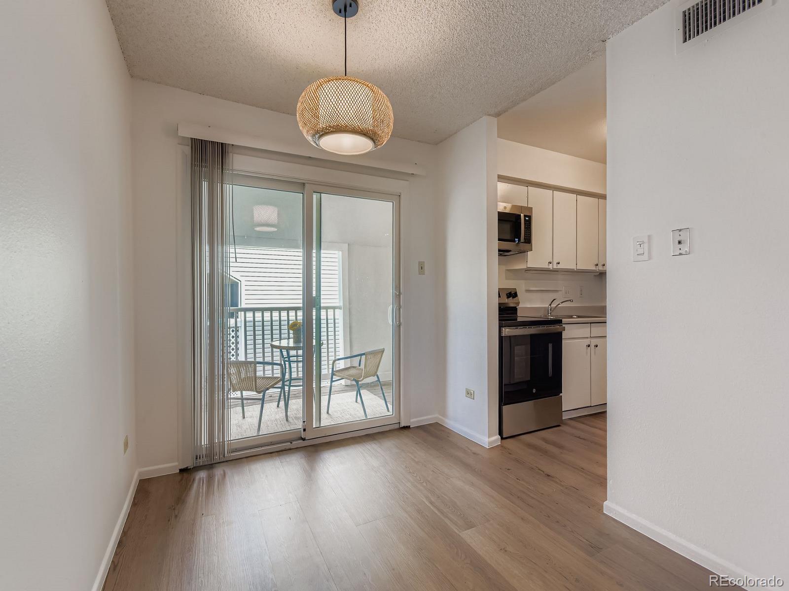 3323 South Monaco Street, Unit D Denver, CO 80222 - Photo 8 of 27 a view of a kitchen with wooden floor and a window