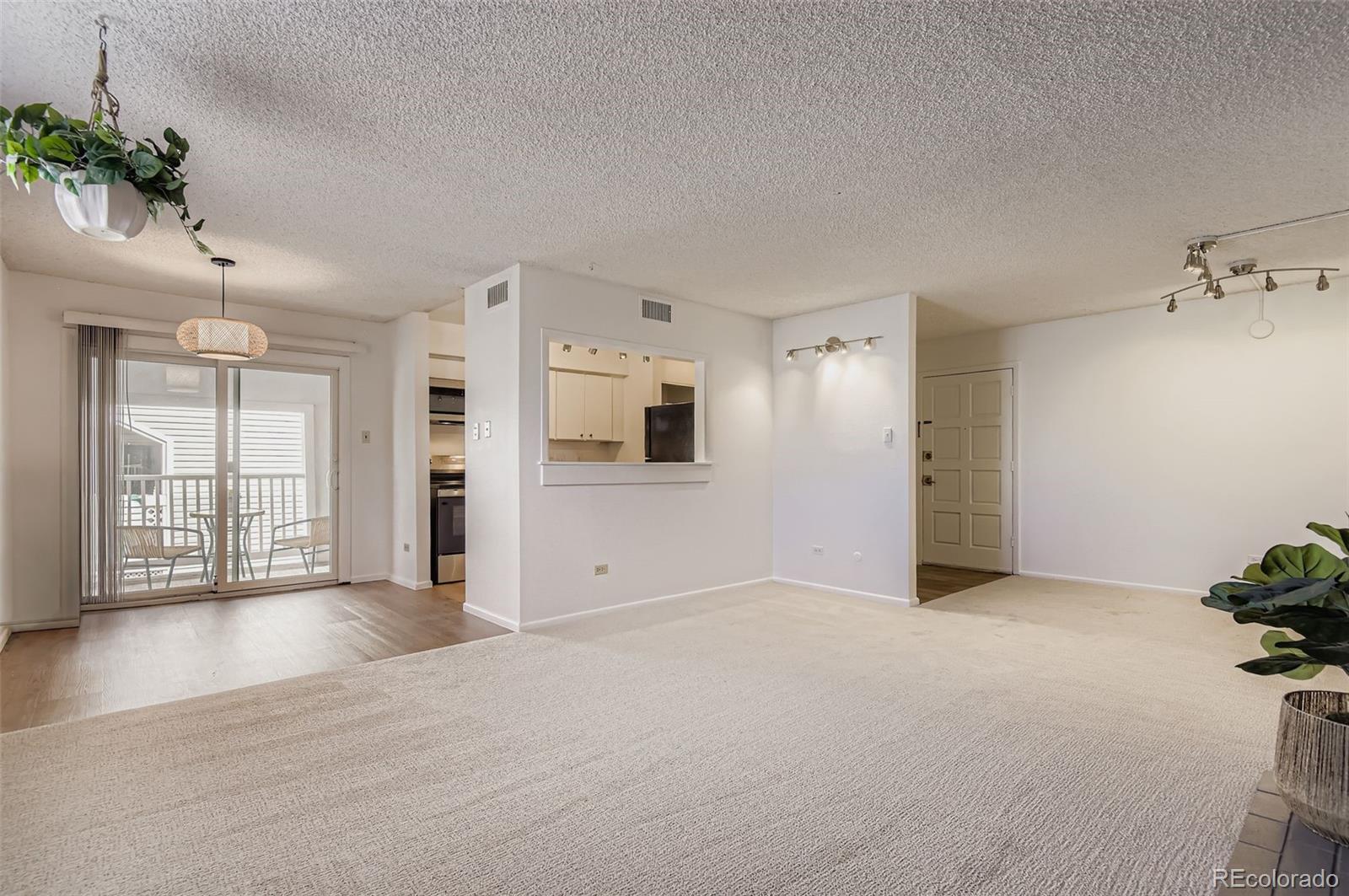3323 South Monaco Street, Unit D Denver, CO 80222 - Photo 9 of 27 a view of an empty room with wooden floor and a window