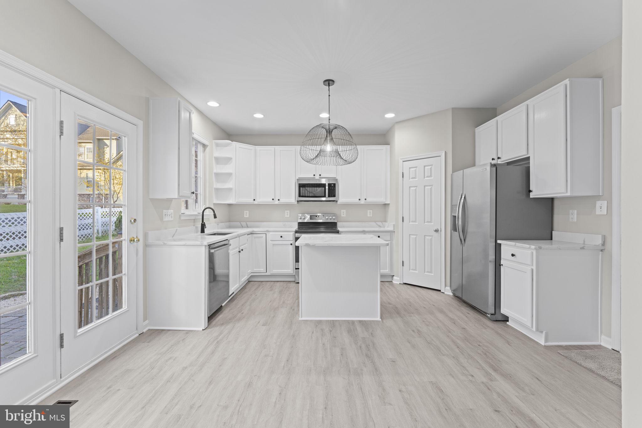 17549 Tedler Circle Round Hill, VA 20141 - Photo 13 of 71 a kitchen with white cabinets and stainless steel appliances