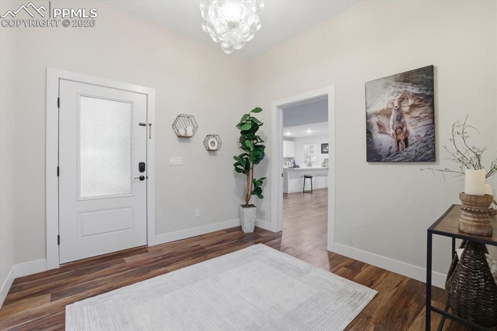 15755 Fool's Gold Lane Colorado Springs, CO 80921 - Photo 6 of 50 a bedroom with a bed and a chandelier