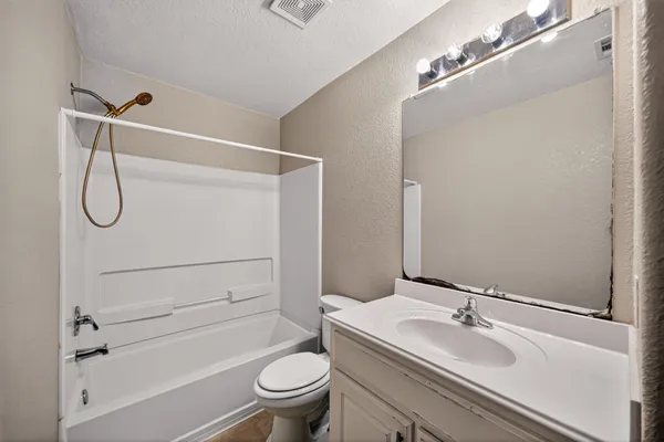 a bathroom with a granite countertop sink toilet and shower