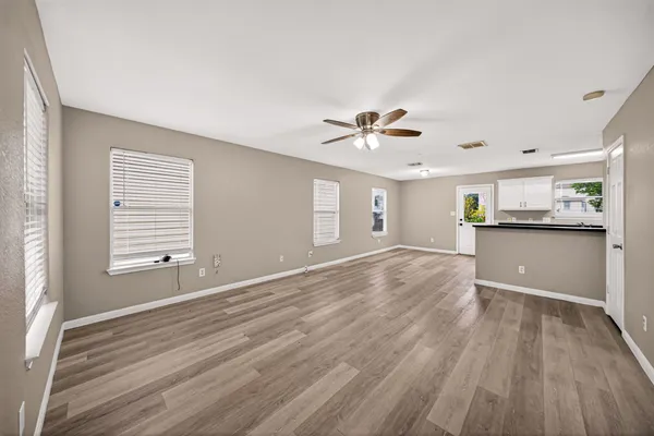 a view of a kitchen with wooden floor and a window