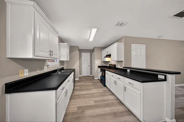 a kitchen with granite countertop a sink and cabinets