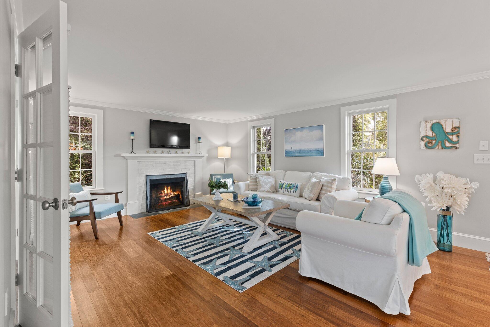 96 Pochet Road Orleans, MA 02653 - Photo 7 of 55 a living room with furniture a fireplace and a table