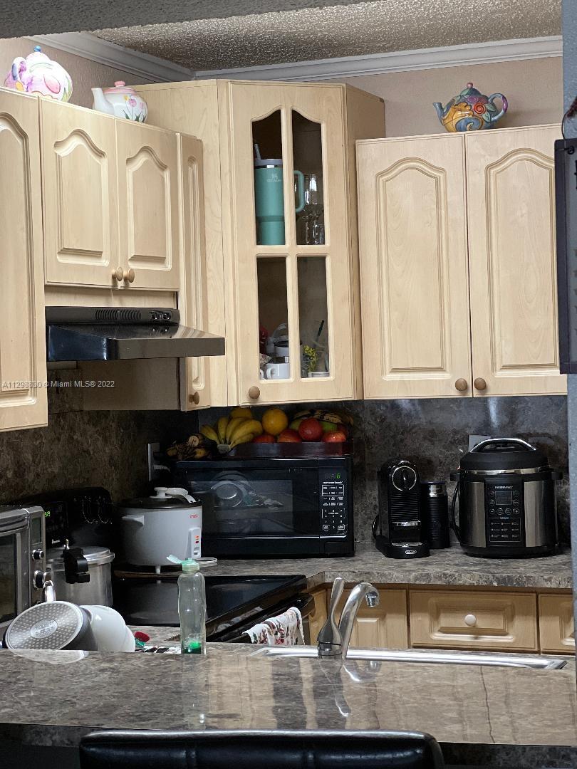 180 Royal Palm Road, Unit 219 Hialeah Gardens, FL 33016 - Photo 6 of 7 a kitchen with stainless steel appliances granite countertop a sink and cabinets