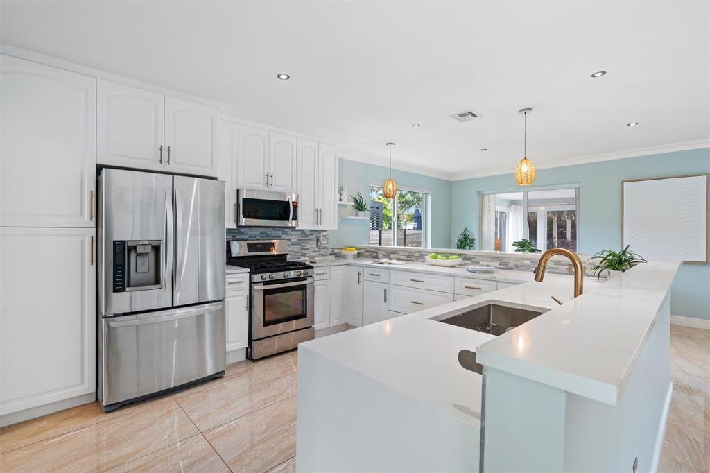 741 Fairway Drive Miami Beach, FL 33141 - Photo 1 of 50 a kitchen with refrigerator and microwave