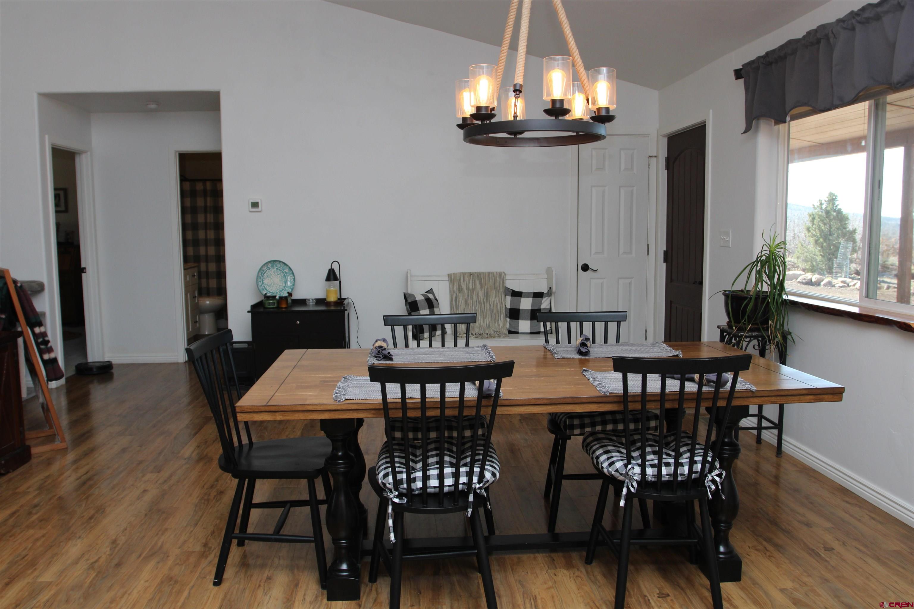25463 Vail Road Cedaredge, CO 81413 - Photo 11 of 28 a view of a dining room with furniture window and wooden floor