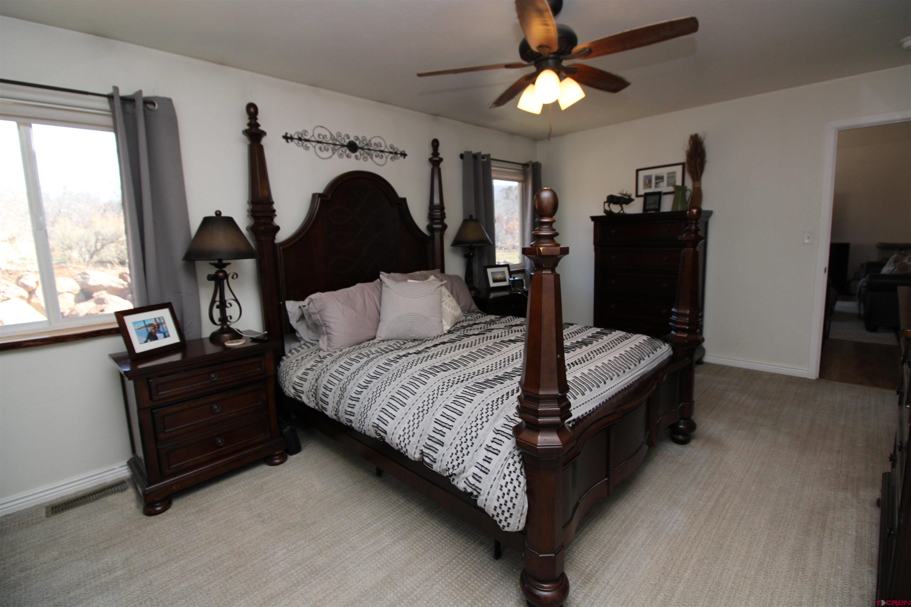 25463 Vail Road Cedaredge, CO 81413 - Photo 20 of 28 a bedroom with a bed and a chandelier