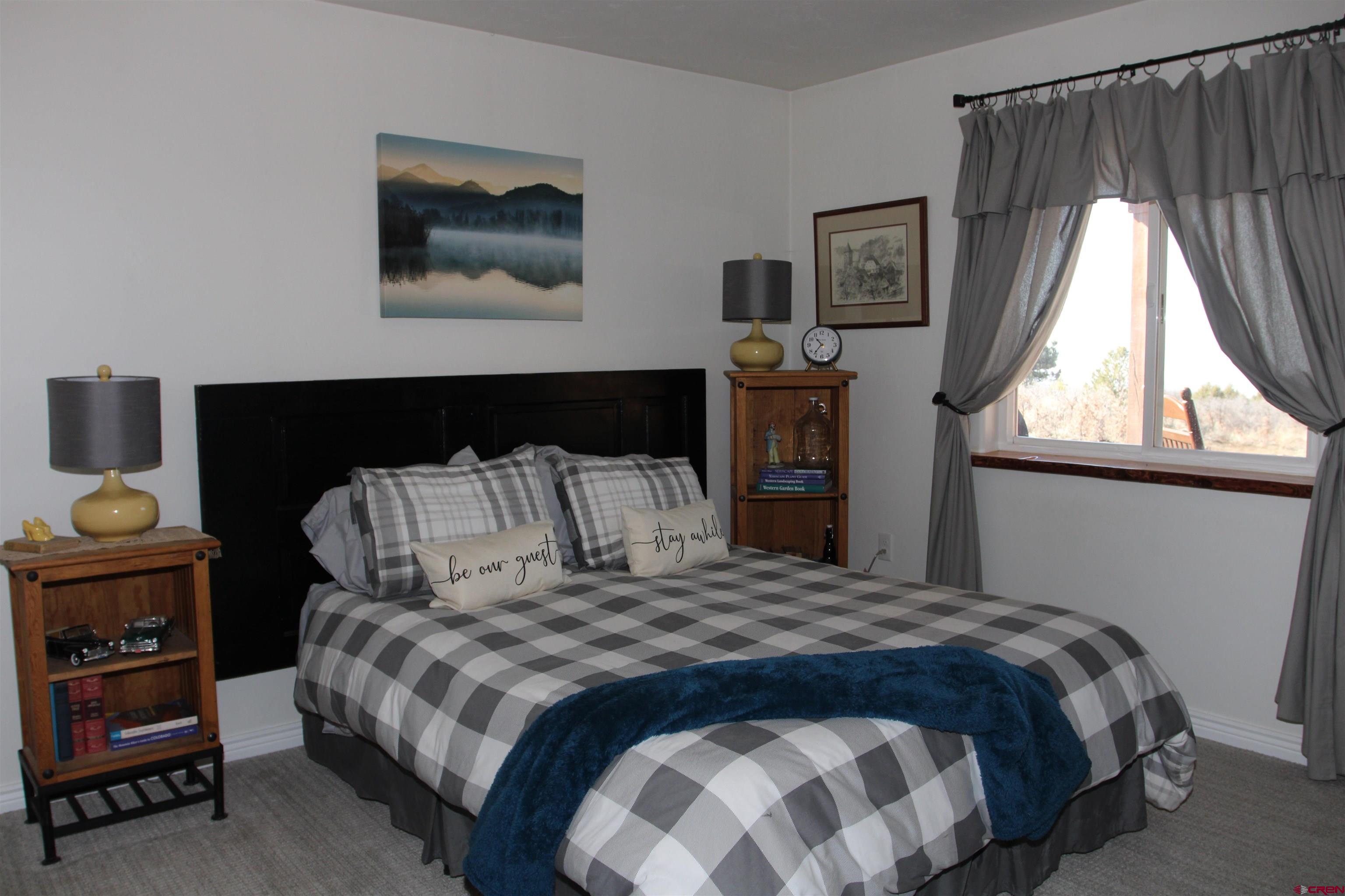 25463 Vail Road Cedaredge, CO 81413 - Photo 24 of 28 a bedroom with a bed and a window