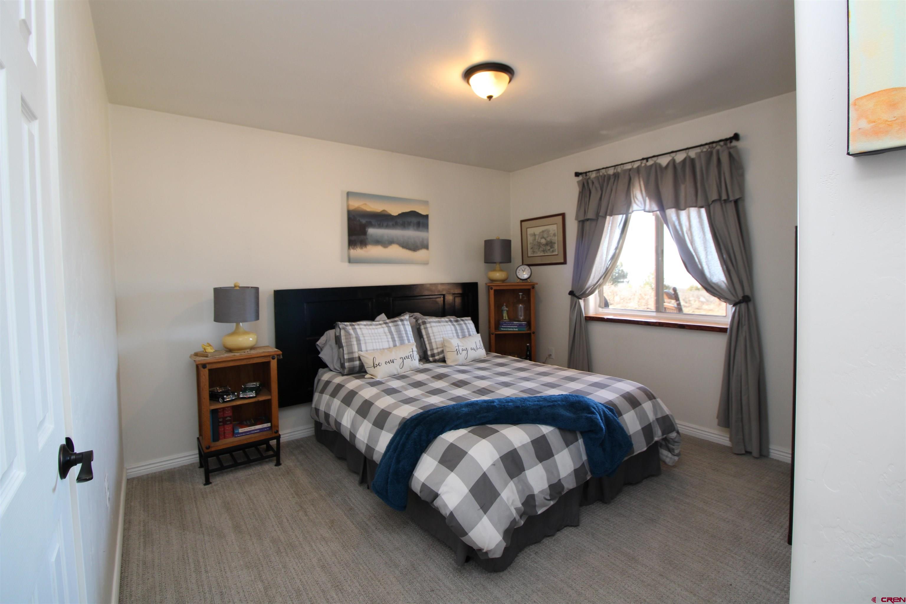 25463 Vail Road Cedaredge, CO 81413 - Photo 25 of 28 a bedroom with a bed and a window