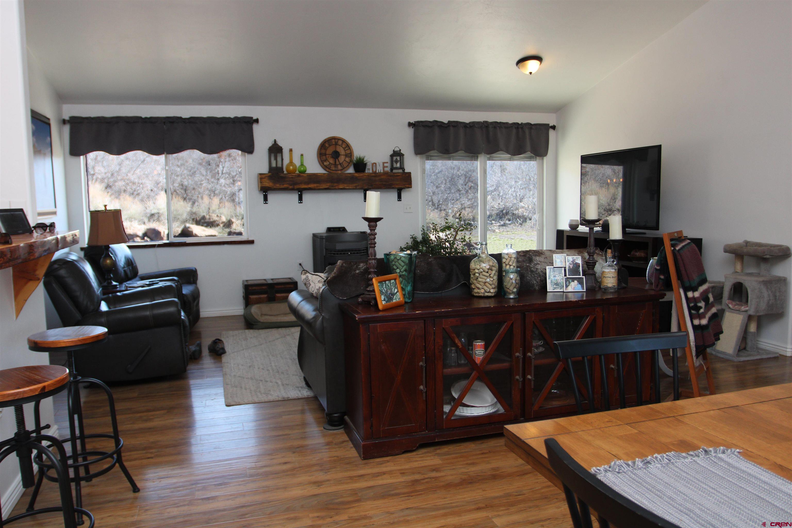 25463 Vail Road Cedaredge, CO 81413 - Photo 5 of 28 a kitchen with stainless steel appliances wooden floors wooden cabinets dining table and chairs
