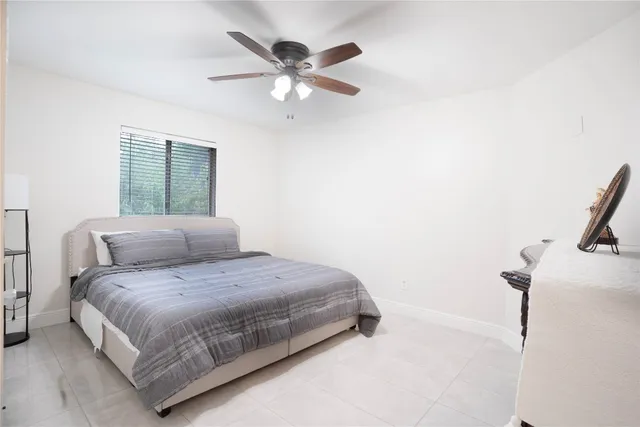 a bedroom with a bed and a ceiling fan
