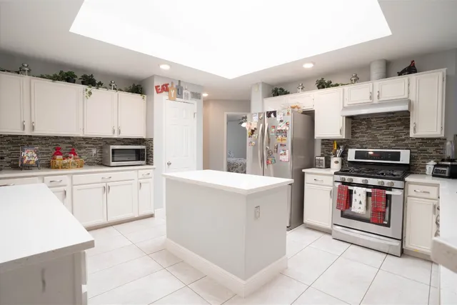 a kitchen with stainless steel appliances a stove refrigerator sink and microwave